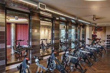a fitness room with bikes and a lot of mirrors